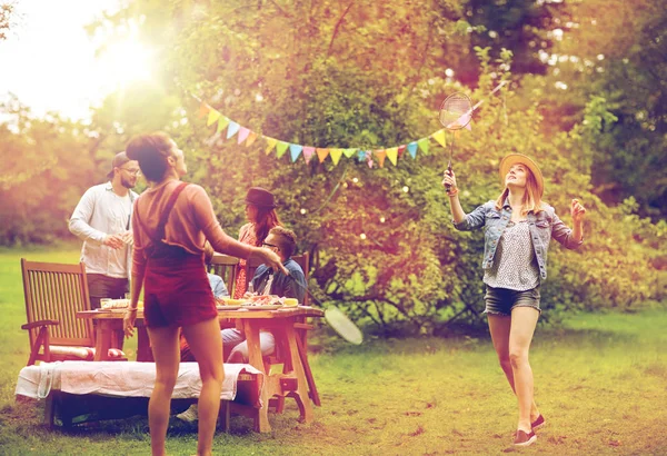 Happy friends playing badminton at summer garden — Stock fotografie