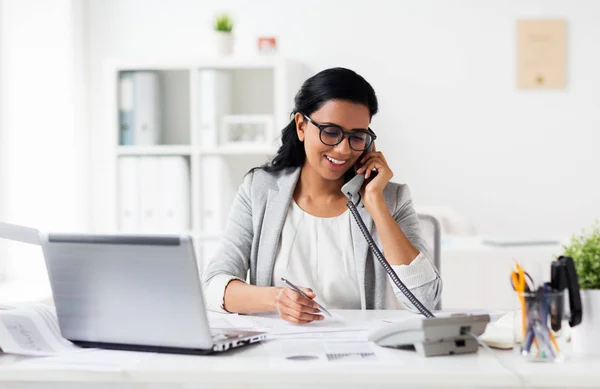 O femeie de afaceri fericită sună la telefon la birou — Fotografie, imagine de stoc