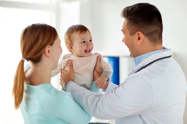 Счастливая женщина с ребенком и врач в клинике — стоковое фото