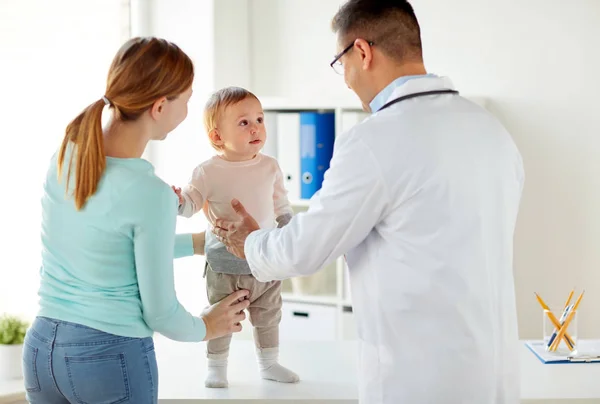 Lycklig kvinna med baby och läkare på kliniken — Stockfoto