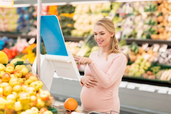 Schwangere mit Grapefruit im Supermarkt — Stockfoto