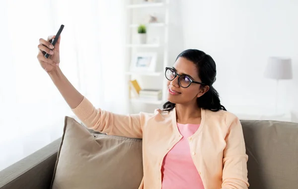 Lycklig kvinna tar selfie med smartphone hemma — Stockfoto