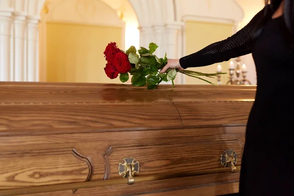 Mujer con rosas rojas y ataúd en el funeral —  Fotos de Stock