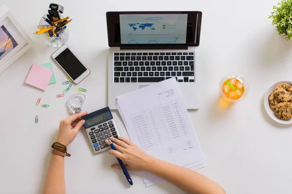 Händer med miniräknare och uppsatser på office tabell — Stockfoto