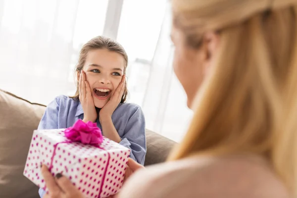 Matka dając prezent urodzinowy dla dziewczyny w domu — Zdjęcie stockowe