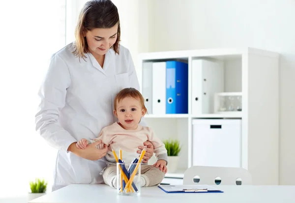 Happy lékaře či pediatra s miminkem na klinice — Stock fotografie