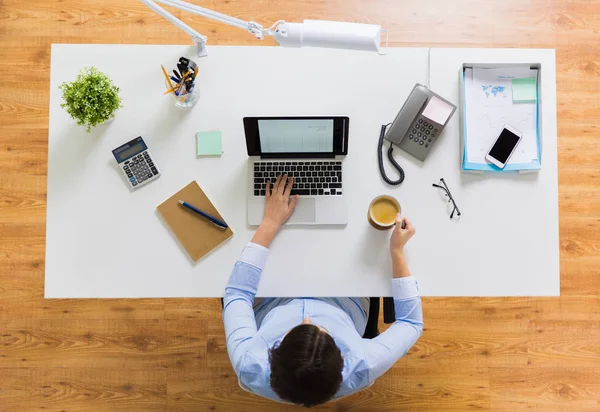 Zakenvrouw met laptop en koffie op kantoor — Stockfoto