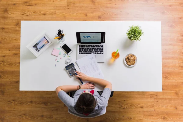 Mulher com calculadora e papéis na mesa do escritório — Fotografia de Stock