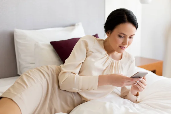 Mujer de negocios con smartphone en la habitación de hotel —  Fotos de Stock