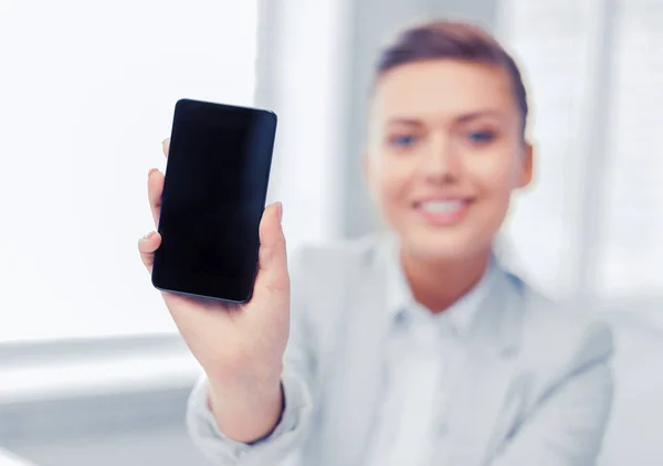 Businesswoman with smartphone in office — Stock Photo, Image