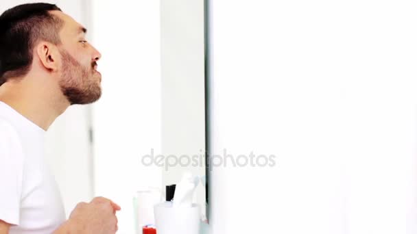 Man with dental floss cleaning teeth at bathroom — Stock Video