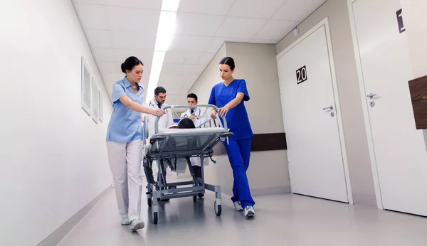 Medics met vrouw op ziekenhuis gurney bij noodgevallen — Stockfoto