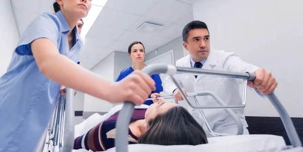 Les médecins avec une femme sur le brancard de l'hôpital à l'urgence — Photo