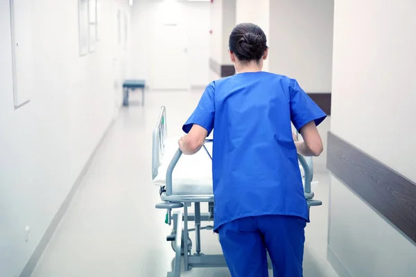 Krankenschwester trägt Krankenhausguru in Notaufnahme — Stockfoto