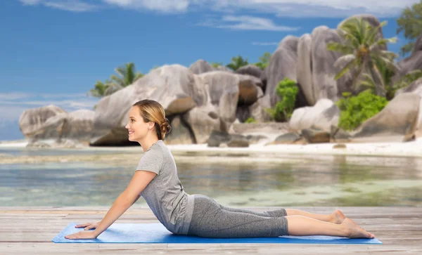 Kvinnan gör yoga i hund pose på stranden — Stockfoto