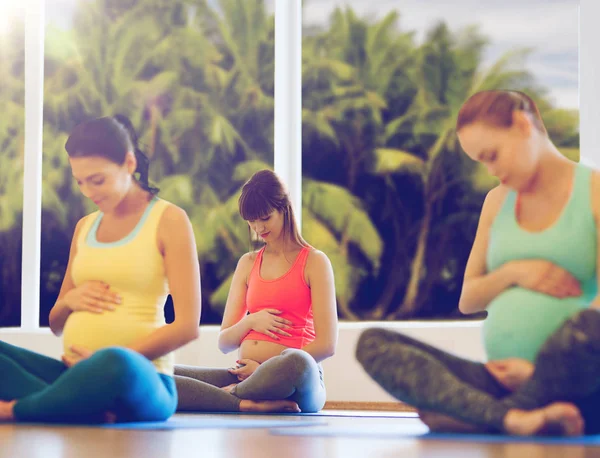 Mulheres grávidas felizes exercitando ioga no ginásio — Fotografia de Stock