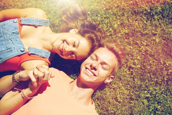 Heureux couple adolescent couché sur l'herbe à l'été — Photo