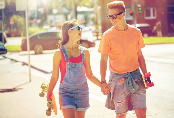 Teenage couple with skateboards on city street — Stock Photo, Image