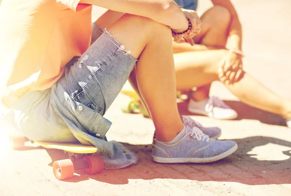 teenage couple with skateboards on city street