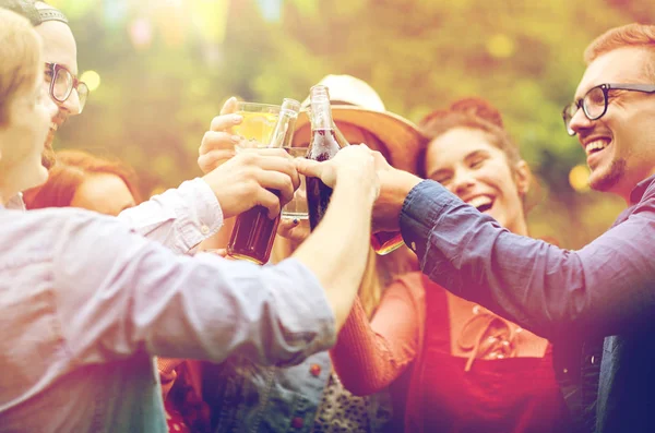 Glada vänner spottar glasögon på summer garden — Stockfoto