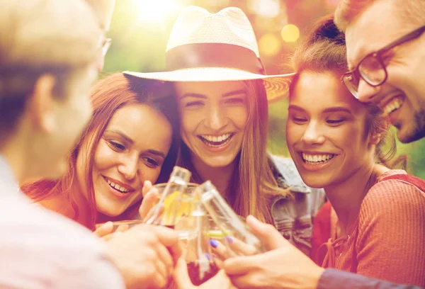 Happy friends clinking glasses at summer garden — Stock Photo, Image