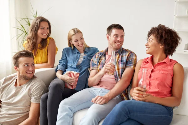 Amigos felices con palomitas de maíz y cerveza en casa — Foto de Stock