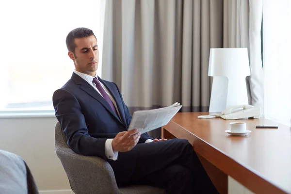 Geschäftsmann liest Zeitung im Hotelzimmer — Stockfoto