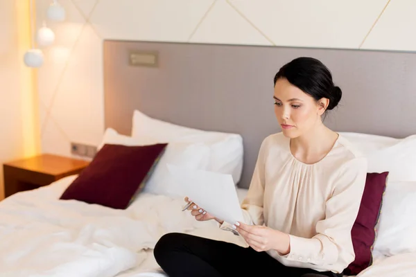 Geschäftsfrau mit Papieren arbeitet im Hotelzimmer — Stockfoto