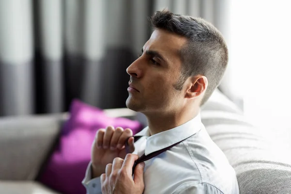 Geschäftsmann zieht Krawatte im Hotelzimmer aus — Stockfoto