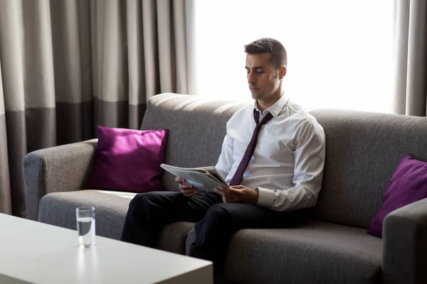Hombre de negocios leyendo periódico en la habitación del hotel — Foto de Stock