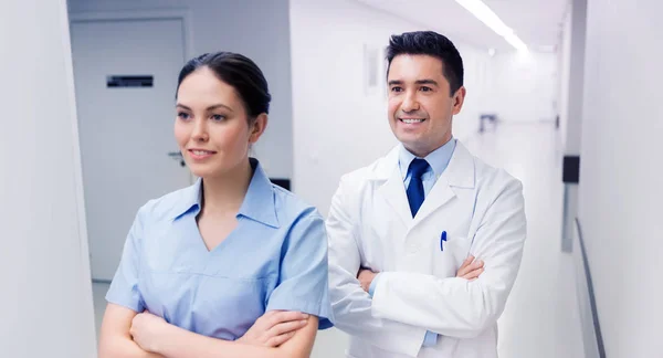 Uśmiechający się lekarza w biały płaszcz i pielęgniarki w szpitalu — Zdjęcie stockowe