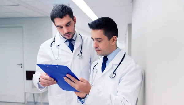 Deux médecins masculins avec presse-papiers à l'hôpital — Photo