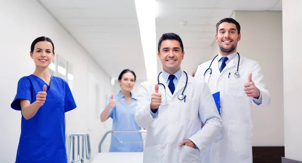 Médicos felizes mostrando polegares no hospital — Fotografia de Stock