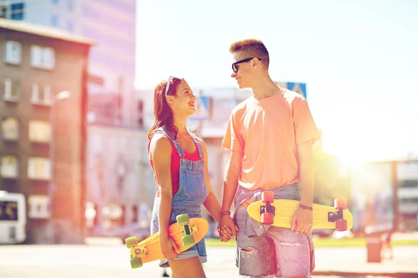 Teenage couple with skateboards on city street — Stock Photo, Image