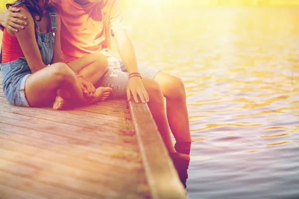 Felice coppia adolescente seduto sul fiume ormeggio — Foto Stock