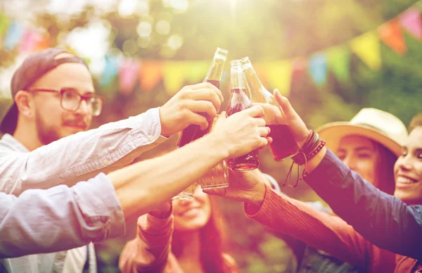 Amigos felices tintineando vasos en el jardín de verano —  Fotos de Stock