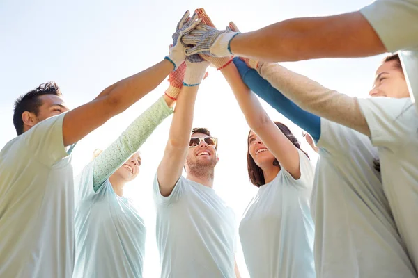 Group of volunteers making high five outdoors — Stock Photo, Image