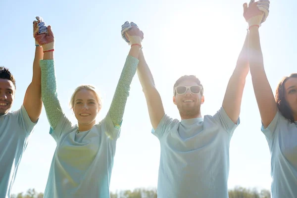 Grupp glada frivilliga hålla händer utomhus — Stockfoto