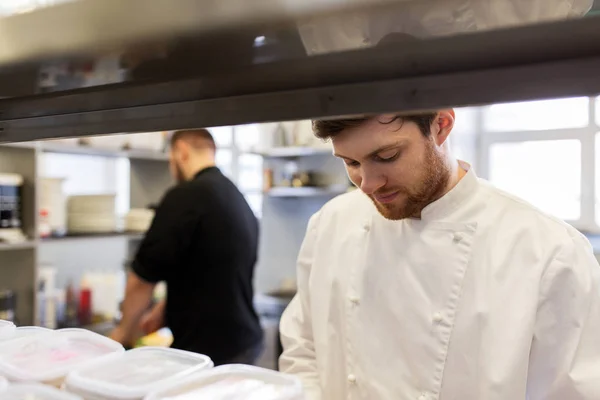 Kuchař a kuchařka vaření v kuchyni restaurace — Stock fotografie