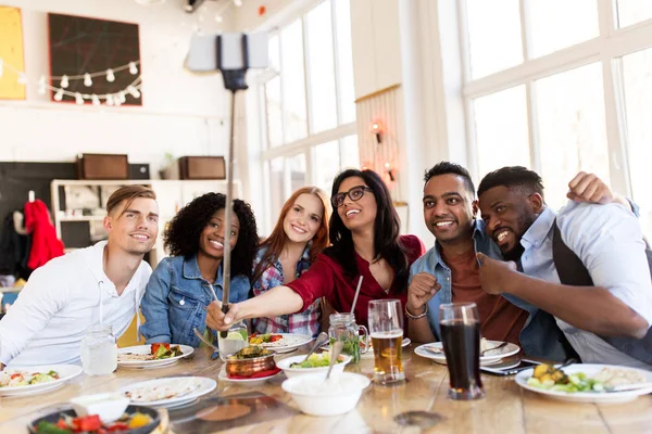Amici mangiare e prendere selfie al ristorante — Foto Stock