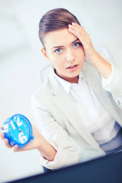 Stressed businesswoman holding clock — Stock Photo, Image
