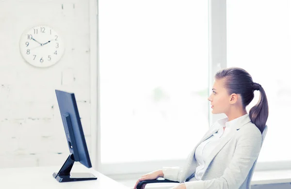 Zakenvrouw kijken naar de klok van de muur in office — Stockfoto