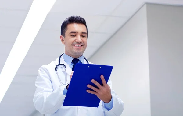 Médecin souriant avec presse-papiers dans le couloir de l'hôpital — Photo