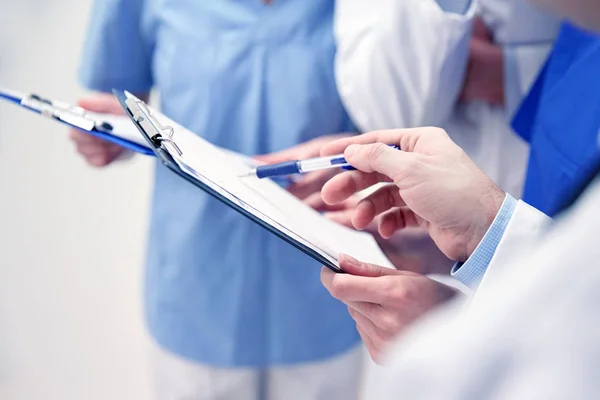 Close up of doctors with clipboard at hospital — Stock Photo, Image