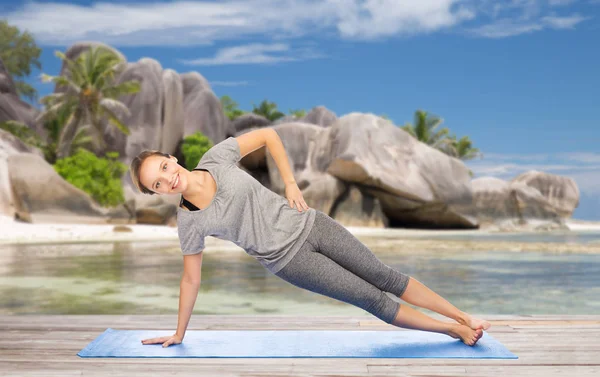 Donna che fa yoga in posa plancia laterale sulla spiaggia — Foto Stock