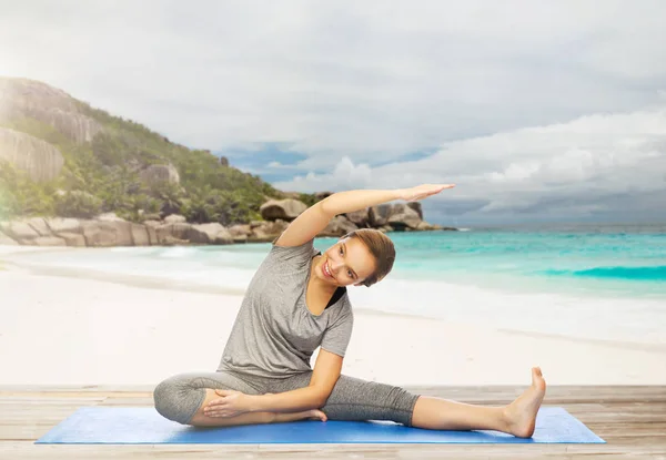 Gelukkige vrouw doen yoga en stretching op strand — Stockfoto