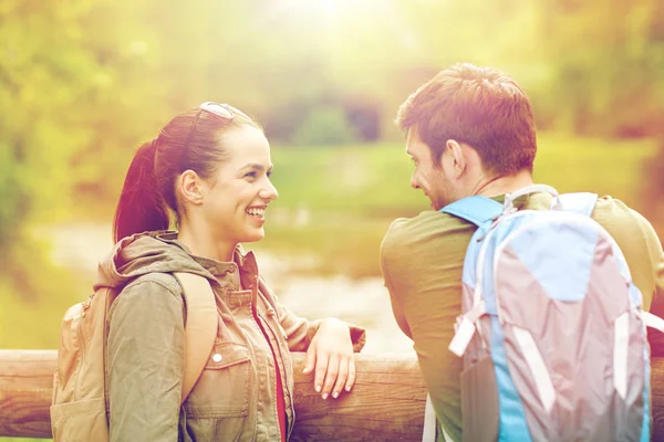 Sorrindo casal com mochilas na natureza — Fotografia de Stock