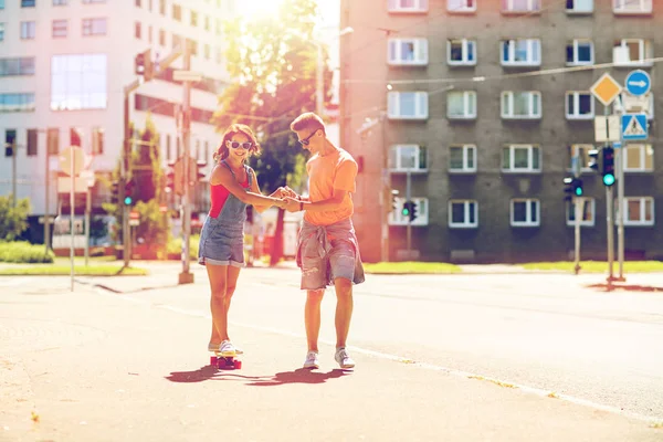 Подростковая пара катается на скейтбордах по городской улице — стоковое фото