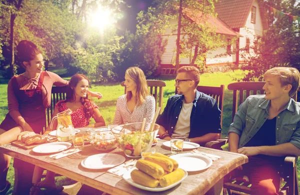 Happy přátelé na večeři na letní zahradní slavnost — Stock fotografie