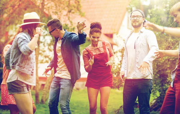 Happy vrienden dansen op zomer party in de tuin — Stockfoto